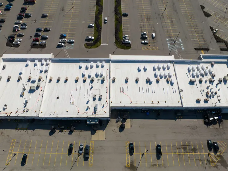 Aerial view of temporary warning lines blown down on a commercial roof before the crew began work